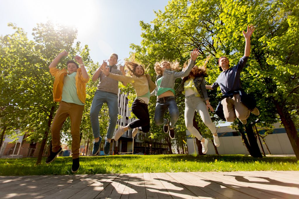happy teenage students or friends jumping outdoors